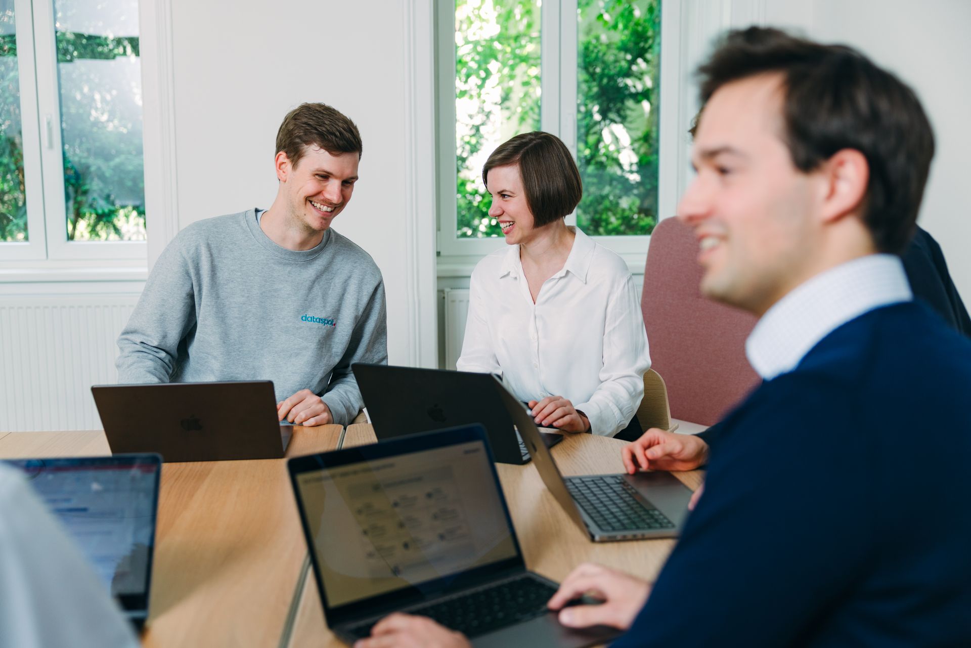 Personen sitzen am Tisch und unterhalten sich